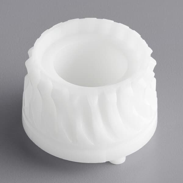 A white plastic object with a circular pattern and a hole in the center.