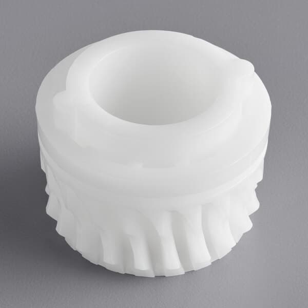 A white plastic gear with a hole in it.