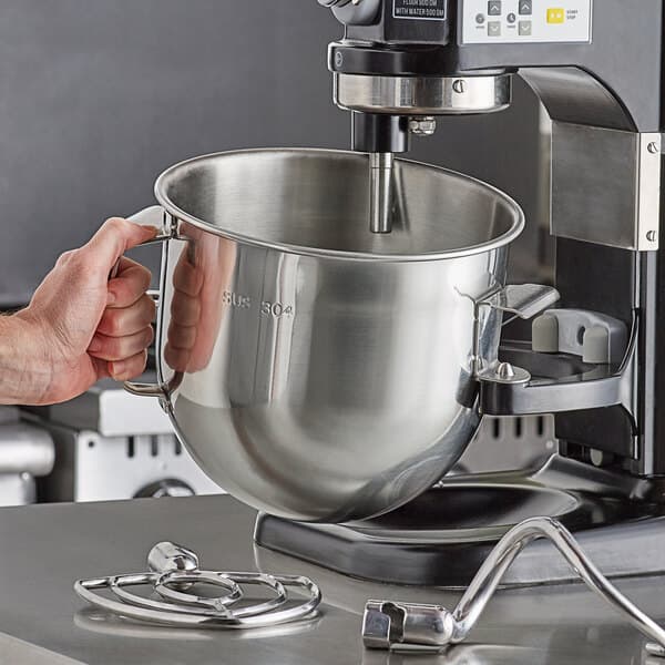 A person holding a large silver Estella mixing bowl.