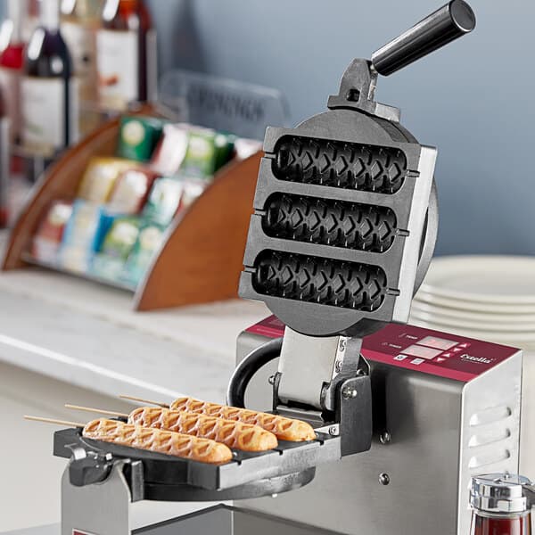 An Estella waffle on a stick plate in a waffle maker.