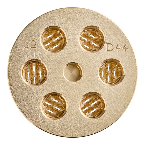 A circular gold pasta die with holes in it.