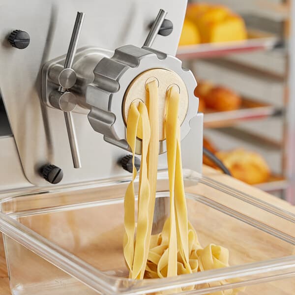 A pasta machine with Estella Fettuccine pasta in it.