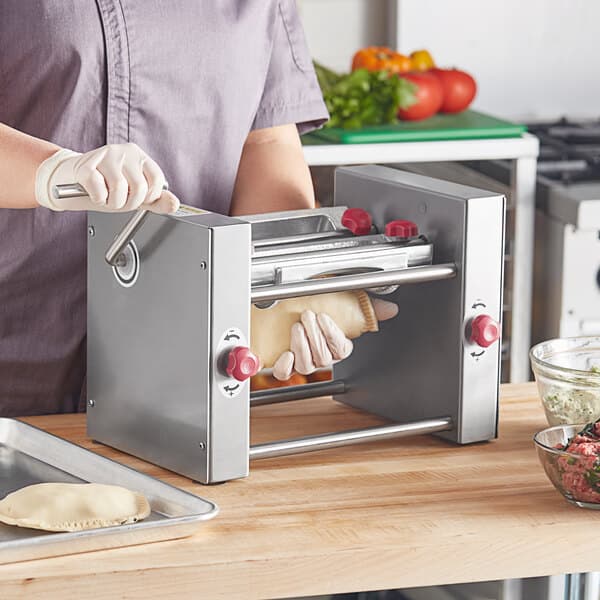 A person using an Estella semi-circle die to make dough.