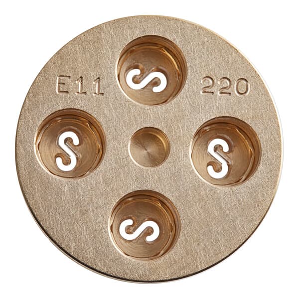 A circular brass Estella Casarecce pasta die with four holes.