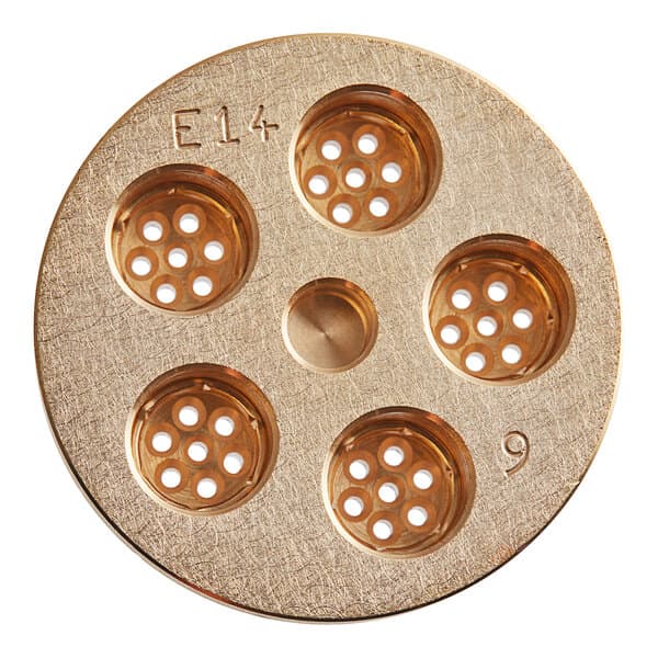 A circular gold metal surface with a circular center with small holes in it.
