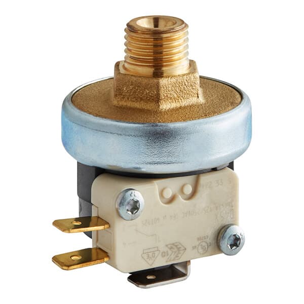 A close-up of a white Estella Caffe pressure switch with a brass nut and round metal object.