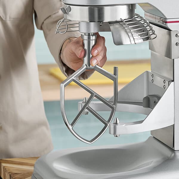 A person using an Estella mixer with a flat beater attachment to make a cake.
