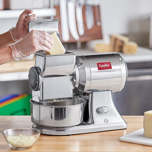 A woman using an Estella electric cheese grater to grate cheese.