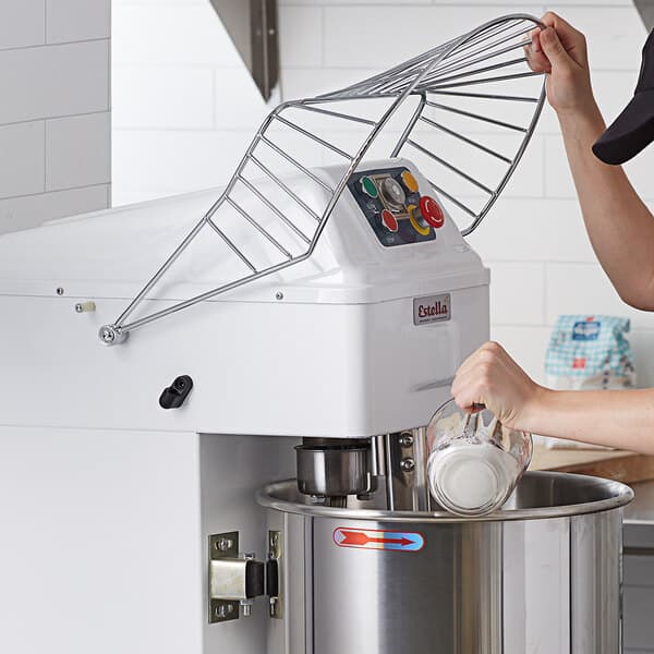 A person using a Estella spiral mixer with a safety guard.