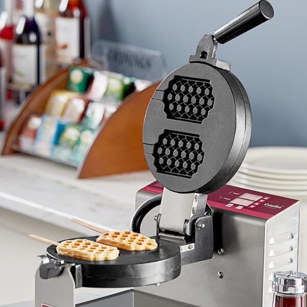 A waffle being made in a waffle maker with a honeycomb pattern on it.