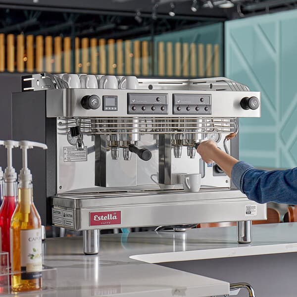 A woman using an Estella Caffe Teapresso machine.