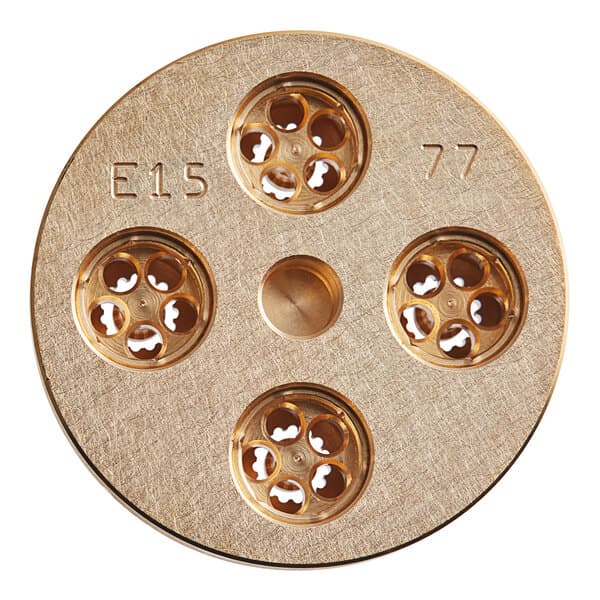 A circular gold metal disc with holes in it.