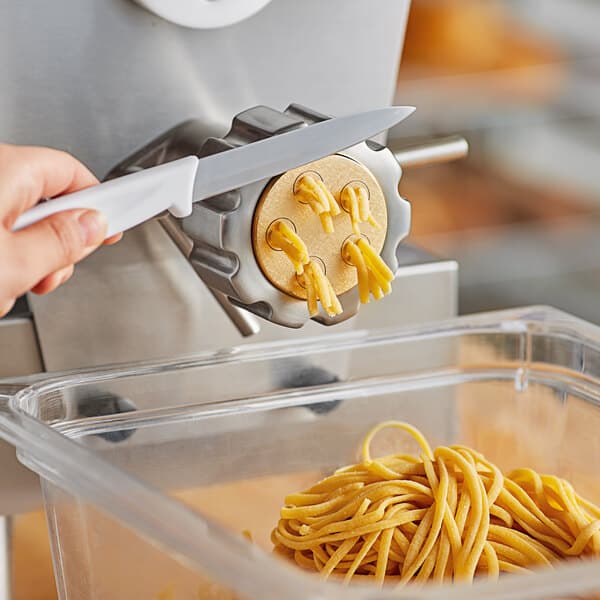 A person using an Estella linguine pasta die to cut noodles.