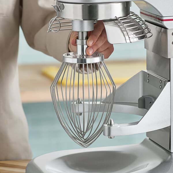 A person using an Estella whip attachment on a mixer.